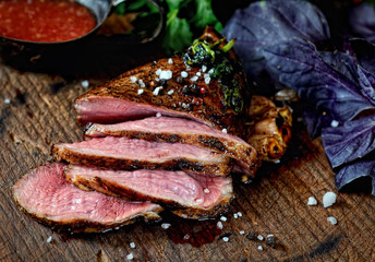 uicy grilled piece of meat on a cutting board, basil, parsley, spices
