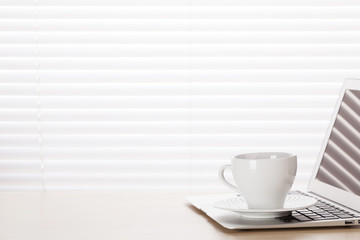 Office workplace with with laptop and coffee cup