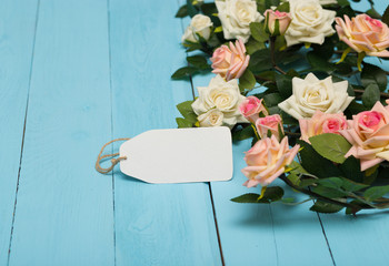white blank card with flowers on a wooden blue background