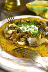Fried potato pancake with mushrooms and onion.