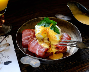 toast with bacon and poached egg in a frying pan