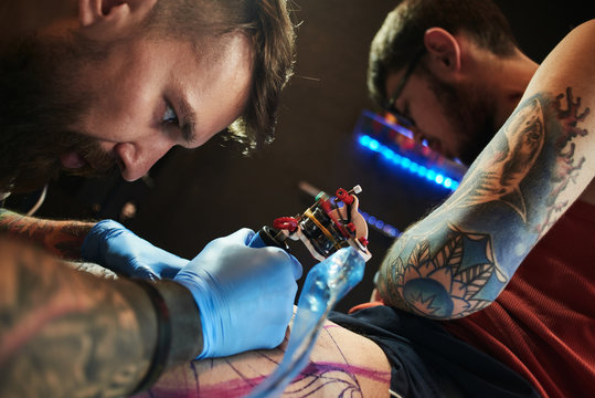 Tattooist makes a tattoo to the client