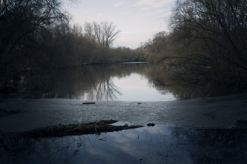 Swamps in autumn. Cool dark lake in primeval forest. Cold melancholic landscape with water vapour. Foggy mystery and mystic wetland with trees. Enigmatic mysterious dark swamp. Eerie situation marsch.