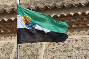 Bandera de Extremadura. Bandera extremeña ondeando al viento. Bandera con escudo.