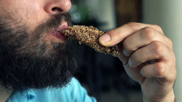 Close up of man face eating sweet cookie, super slow motion 240fps
