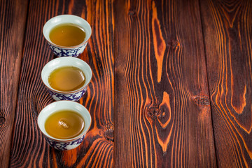 Cups with green tea on wooden background