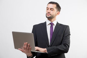 Young business man with a laptop in a studio