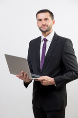 Young business man with a laptop in a studio