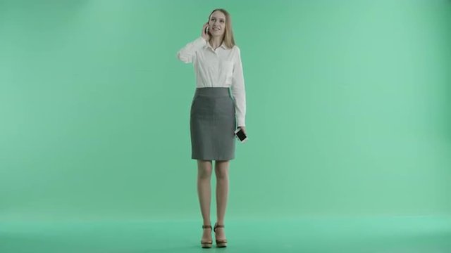 business woman talking on two phones at the same time on a green screen