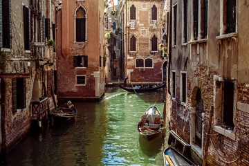 Obraz na płótnie Canvas Horizontal oriented image of gondola passing on small canal among old historic houses in Venice, Italy