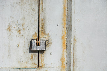 Steel lock on the rusty grey metal door. close-up. 
