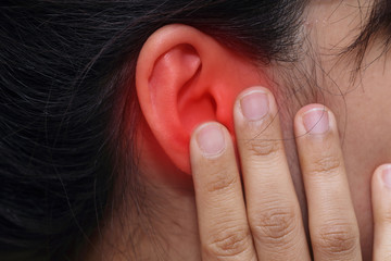 woman hand touch her ear with pain