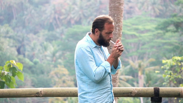 Man lighting cigarette in garden, super slow motion 240fps
