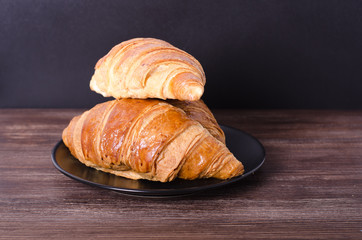Fresh croissants on wooden background. Free space for your text.
