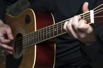 Fototapeta premium Closeup of man's hands playing on guitar