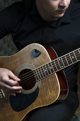 Young guitarist playing on acoustic guitar