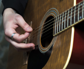 Obraz premium Acoustic guitar in man's hands, closeup.