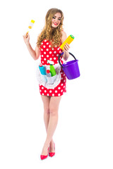 Fototapeta na wymiar Attractive pin-up girl in red dress with polka dots. Cleaning the house. Housewife with accessories for cleaning on a white background. Retro style. Fashion.