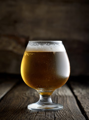 beer in a glass on a wooden background