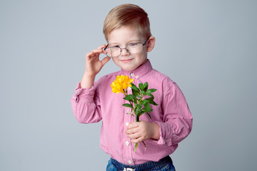 A cute little boy is dressed in a checked pink shirt and glasses