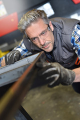 Fototapeta na wymiar Metalworker checking piece of iron in workshop