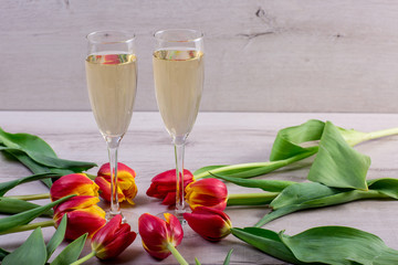 photo of two champagnes glasses and bottle on white wooden table with copy space.