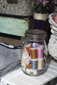 glass jar with a spool of thread
