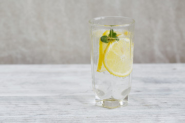 Lemonade with fresh lemon on wooden background