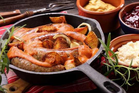 White sausages with barbecue sauce baked in a frying pan