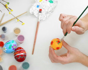 Female hands painting Easter egg at table, top view