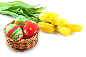 Multicoloured Easter eggs in a wicker bowl isolated on white