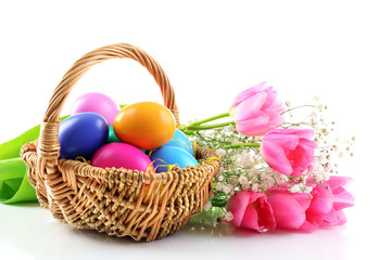 Multicoloured Easter eggs in wicker basket isolated on white