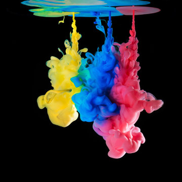 Colored ink drops in water on black background