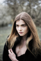 Obraz premium portrait of a beautiful girl in a black coat on the nature