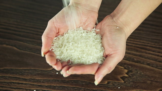 Rice pours into the hands of a girl