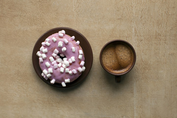 Espresso and pink donut on table