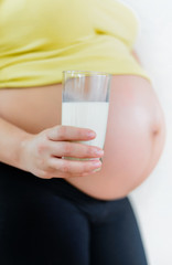 Pregnant woman holding a glass of fresh milk