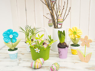 Schöne Oster-Tischdekoration mit bemalten Eiern, Frühlingsblumen und selbstgemachte Stoffblumen in Pastellfarben 