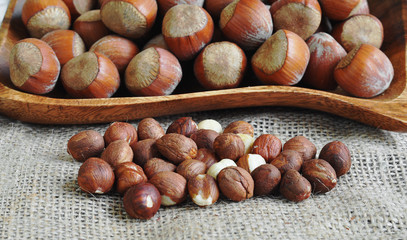 Whole hazelnuts and shelled hazelnuts on the wood plate.