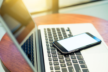 Laptop computer and cellphone on table