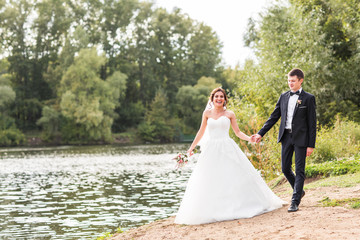 Wedding couple walking  near lake.