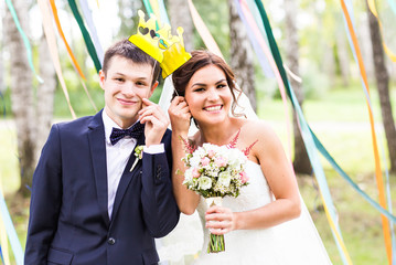 April Fools' Day. Wedding couple posing with crown, mask.