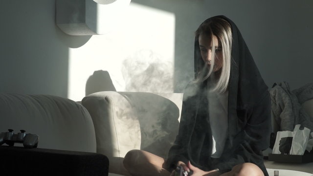 Girl with piercings and tattoos smokes hookah