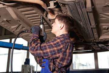 Worker of service station repairing car