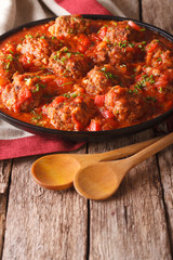 Albondigas meatballs with tomato sauce on a plate close-up. Vertical
