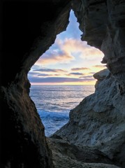 Obraz premium A colorful sunset sky framed by natural arch at Sunset Cliffs, Point Loma, California