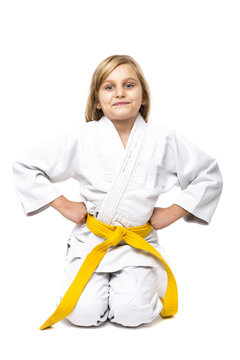 Pretty little girl in white kimono down on knees ready to fight