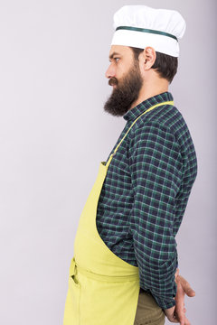 Studio shot of a bearded man with apron and cook hat