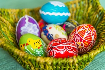 Closeup of beautiful colorful hand painted easter eggs in basket. Selective focus