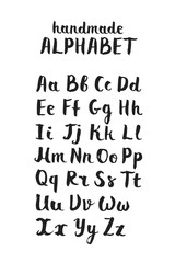 Handwritten calligraphic white alphabet written with brush pen on black background. Handmade ABC font typography